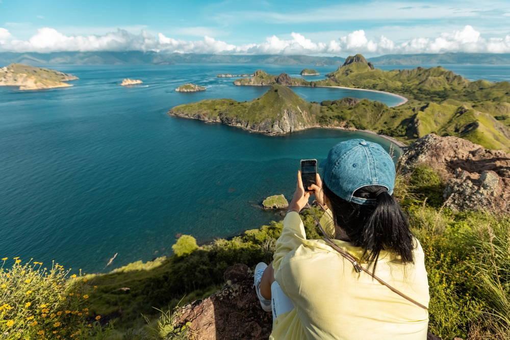 Traveller photographing the famous three-bay viewpoint on Padar Island, Komodo National Park